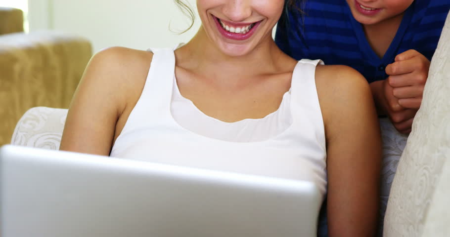 Smiling women and her son looking at the laptop on the couch | Shutterstock HD Video #16382959