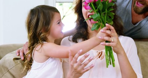 Caucasian mom receiving roses from his daugther