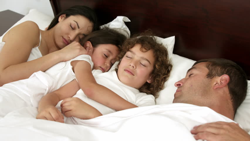 happy-family-sleeping-same-bed-100-16385836