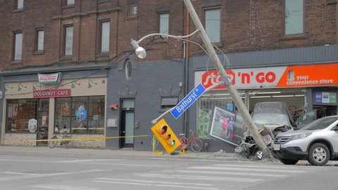 TORONTO, CANADA - CIRCA APRIL 2016: Toronto Police & Fire Emergency Services, looking onto crime scene of car crash through a convenience store window from behind yellow police line do not cross tape.