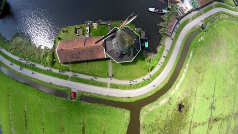 Aerial top down view Zaanse Schans one of most popular tourist attractions of Netherlands Holland near Amsterdam beautiful drone footage moving up looking down on windmills mills renewable energy 4k