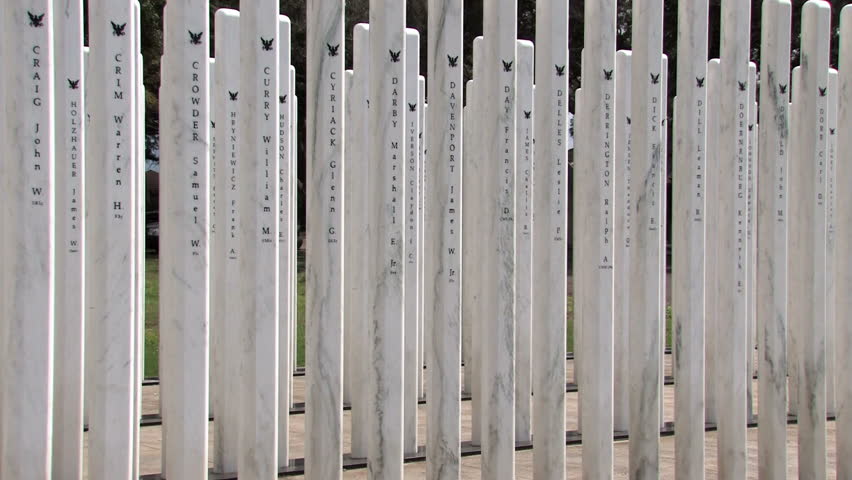 Pan left of USS Oklahoma Memorial on Ford Island in Pearl Harbor, Honolulu, Oahu, Hawaii. Names of those killed in action aboard the battleship. Engraved sign with vertical posts with each name. 
