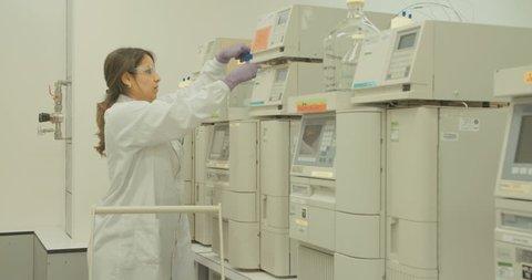 Researcher working with mass spectrometers in a pharmaceutical research lab