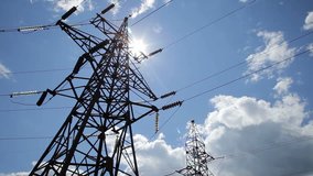High voltage towers with sky background. A high voltage power pylons against blue sky and sun rays - Stock Video