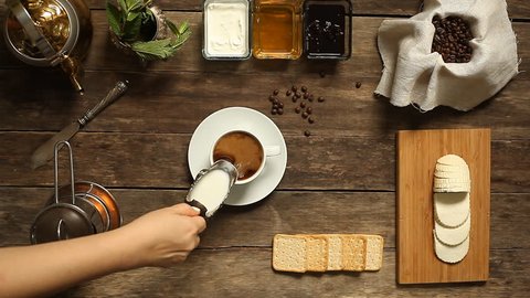 coffee. vintage. wooden background.  top view. fresh cream poured into a black strong coffee.  overhead horizontal view Stock Video