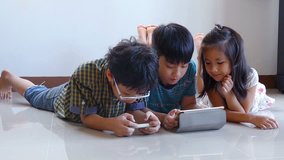 Young asian boys playing online games on tablet computer and smart phone 