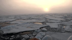 Sunset in the ocean among the icebergs and ice in the Arctic. Fantastic wonderful amazing video grenland nature iceland. Lovely shooting the life of nature, seaside and mountains. Global warming.