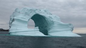 Iceberg arch like Darwin arch in Galapagos Islands. Fantastic wonderful amazing video grenland nature iceland. Lovely shooting the life of nature, seaside and mountains. Global warming.