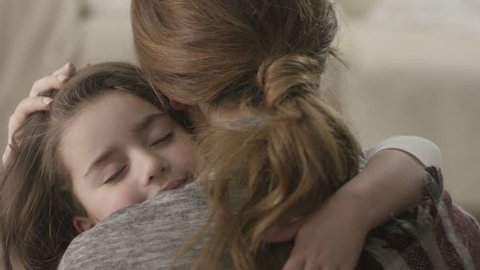 Daughter rushes into mother's arms at home and gives her a big hug. Shot on RED EPIC Cinema Camera in slow motion.