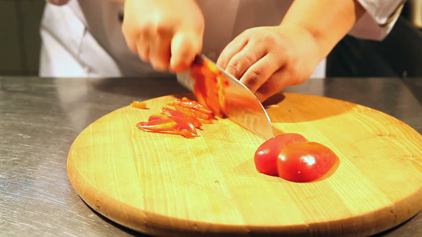 Chef on a cutting board cut the red pepper