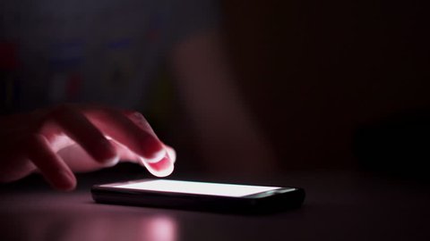 Person using smart phone in dark room 4k Smart phone used in dark, a little bit of covert browsing at night.