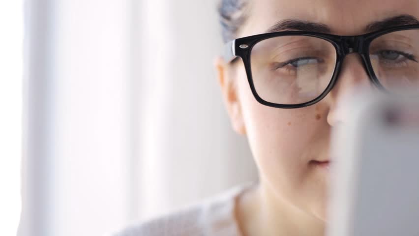 People, technology and leisure concept - young woman in eyeglasses with smartphone at home | Shutterstock HD Video #16465102