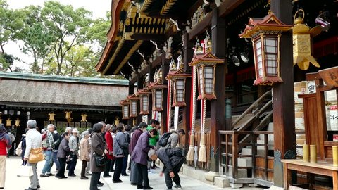 KYOTO, JAPAN -NOV 25, 2015: Tourists rang the bell for blessings at the Kitano Tenmangu Shrine in autumn, Kyoto, Japan. This shrine built in the northwest section of Kyoto over 1000 years ago 