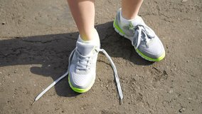 girl stopped running to tie the laces on running shoes. fitness girl training outdoors