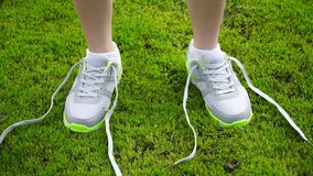 girl stopped running to tie the laces on running shoes. fitness girl training outdoors
