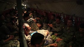 Muisine, Ecuador, April 2016: Soldiers in The Ecuadorian Armed Forces in the cargo area of  FAE-1032 military aircraft bowing their heads in prayer during a flight after the 2016 earthquake
 - Powered by Shutterstock - Get 15% off with code: PIKWIZARD15