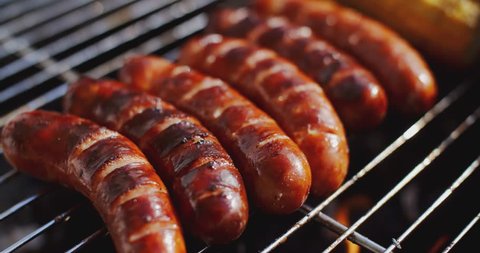 Tasty juicy sausages grilling over a fireの動画素材