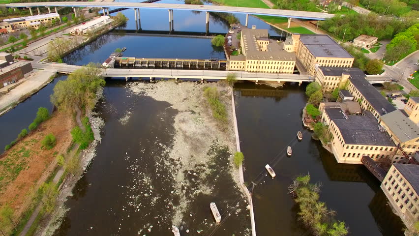 Scenic aerial flyover of Appleton Wisconsin riverfront with buildings, damn, bridges, seagulls.
