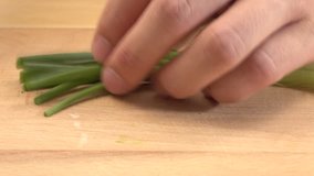 Spring onions being chopped on chopping block