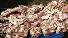 Lots of skewers with meat for barbecue cooking are waiting. Outdoors video.