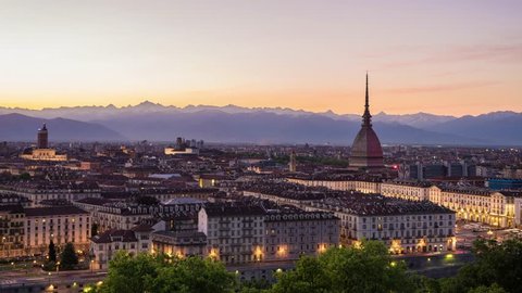 Torino, Italy - May 4, 2016: Turin time lapse, Torino time lapse panoramic cityscape fading from sunset to night. Mole Antonelliana with Torino FC colors in memory of the 1949 Superga airplane crash.