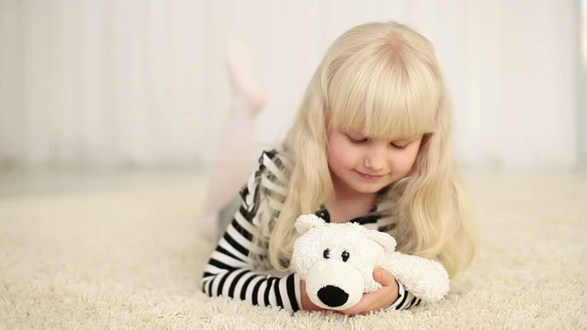 Happy girl with teddy bear looking at camera 