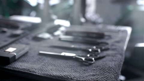 Closeup of tools, scissors, comb and razor in barber shop or men's beauty parlor. Dolly shot 