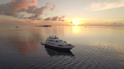 Flight over of luxury boat at tropical sunrise - Maldives Island 2015.
