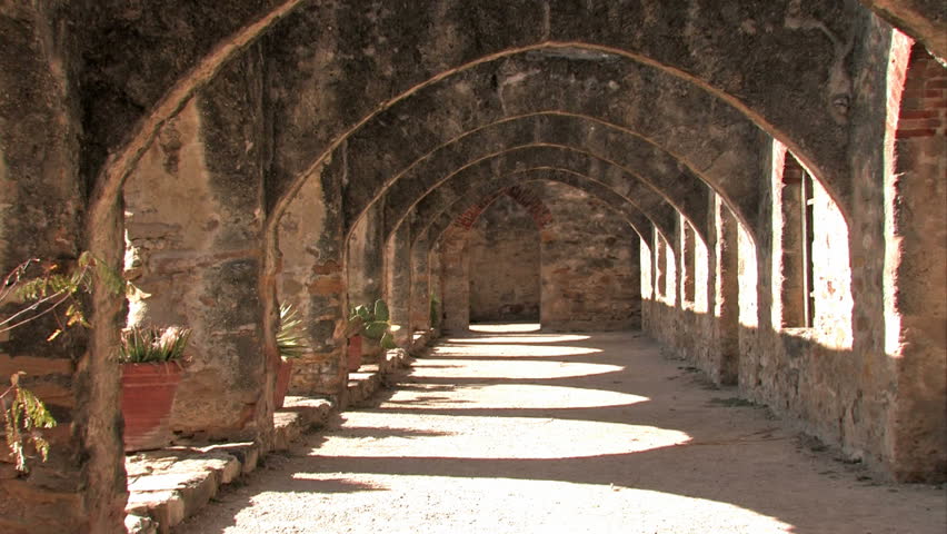 Old Spanish Mission San Jose San Antonio, Texas. Courtyard arched walkway towards main cathedral. Dramatic shadows.  Built in 1720s 