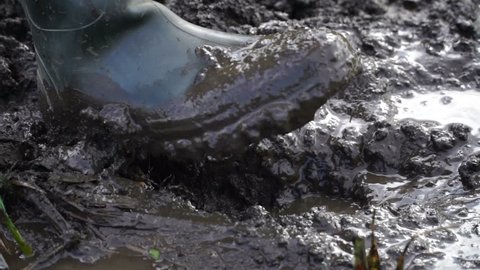 a man in rubber boots walking on the mud. HD video