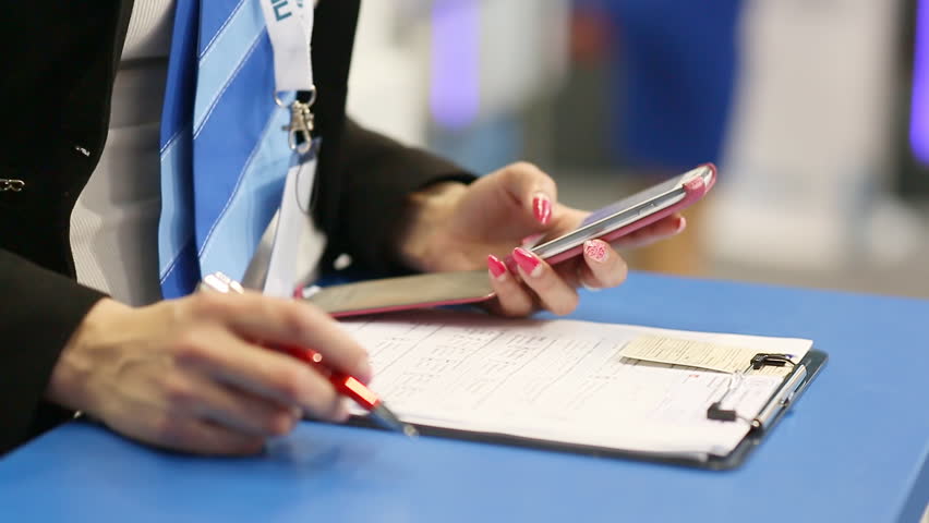 Woman working with phone and notebook.