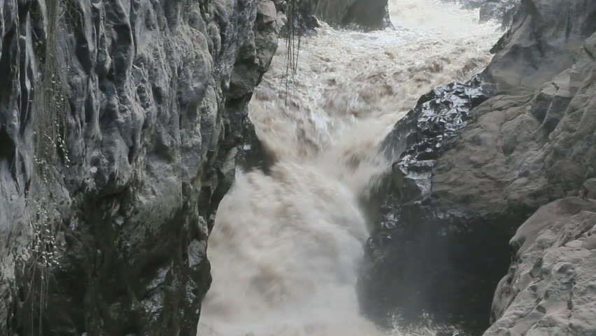 Muddy stream rushing trough Volcanic rocks on Mt,Tungurahua Ecuador.Observe the