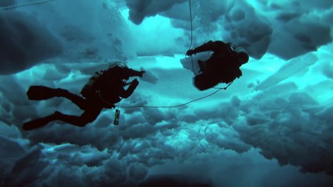 Unique extreme underwater shooting scuba dive beneath ice at geographic  North Pole in cold waters. Fantastic views of the lump of ice in water. ICE CAMP BARNEO, NORTH POLE, ARCTIC - APRIL 10, 2015