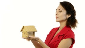 Concept - risk to lose your real estate . Woman holding and destroy wooden toy model house against isolated white backgroung in studio 