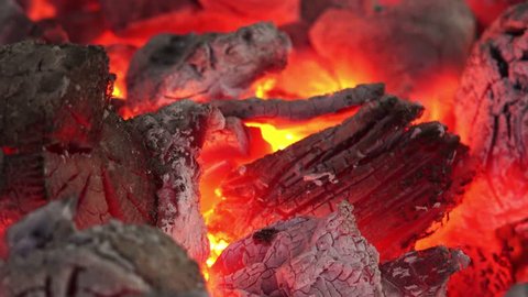 Charcoal and firewood burning in a grill, close up footage.
