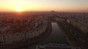 Aerial view over Bucharest City center skyline with Unirii Boulevard, National Library, Dambovita River and House of Parliament or House of People on the background at dusk.