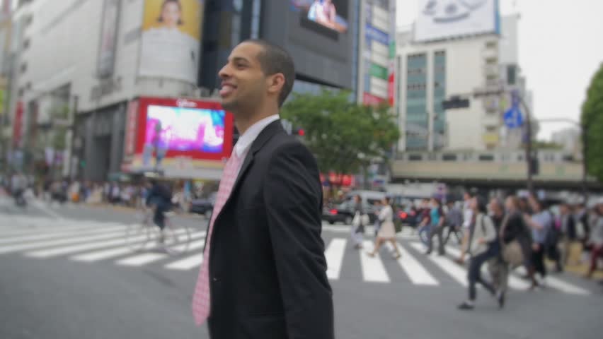 Confident young mix race business man walking Hachiko Exit Shibuya crossing feeling Sucessful    