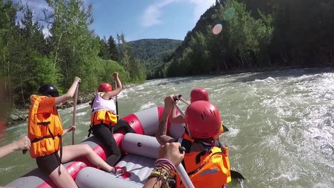 Group of six people white water rafting 