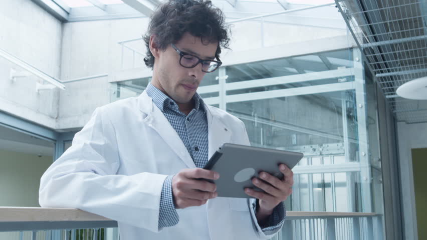 Latin Ethnicity Student of Medical School using Tablet Computer in Hallway. Shot on RED Cinema Camera in 4K (UHD).