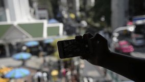 Silhouette of Unknown man taking a photo via smartphone in city of Bangkok,Thailand
