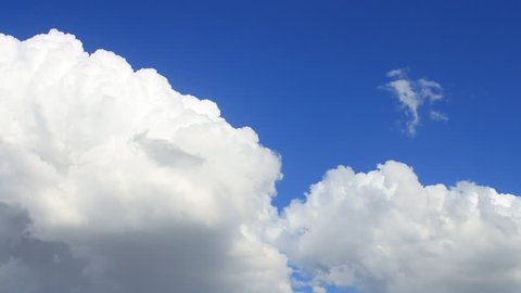 Time Lapse, motion white, gray, puffy clouds on the background blue sky