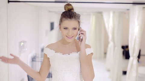 Bride talking on the phone in bridal store