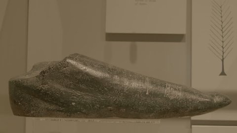 Bahrain National Museum, Bahrain - circa 2011 - Medium rack-focus on a piece of black basalt carved with a feather and cuneiform writing from the Sumerian collection.