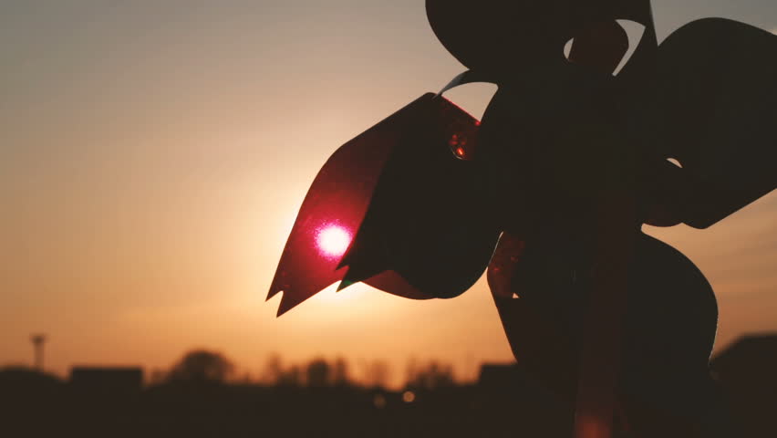 Pinwheel windmill against a sun. Windmill silhouette. Video full hd.