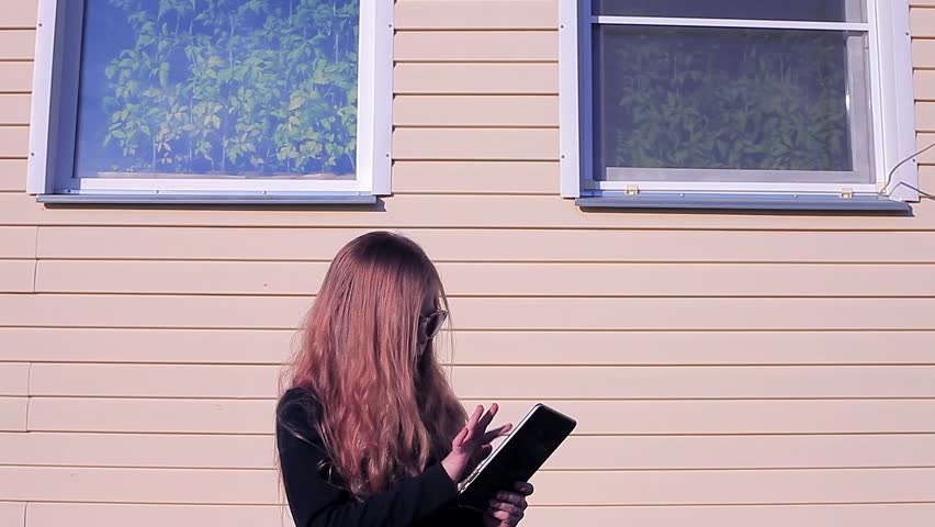 Beautiful Girl With Long Hair is Gaining on the Tablet, Girl Online Looking For the Kids Goods,