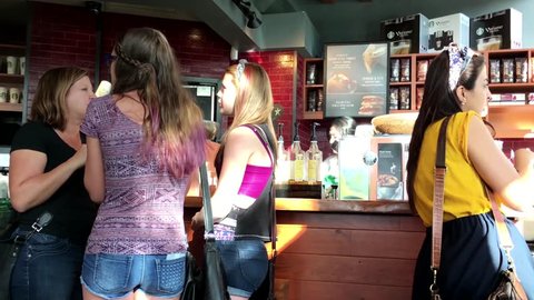 Coquitlam, BC, Canada - May 07, 2016 : People chatting while waiting for coffee inside Starbucks store with 4k resolution.