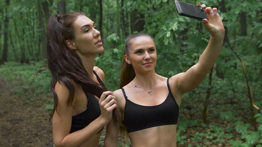 Beautiful girls taking a selfie with a smart phone before going for a run outdoors. 