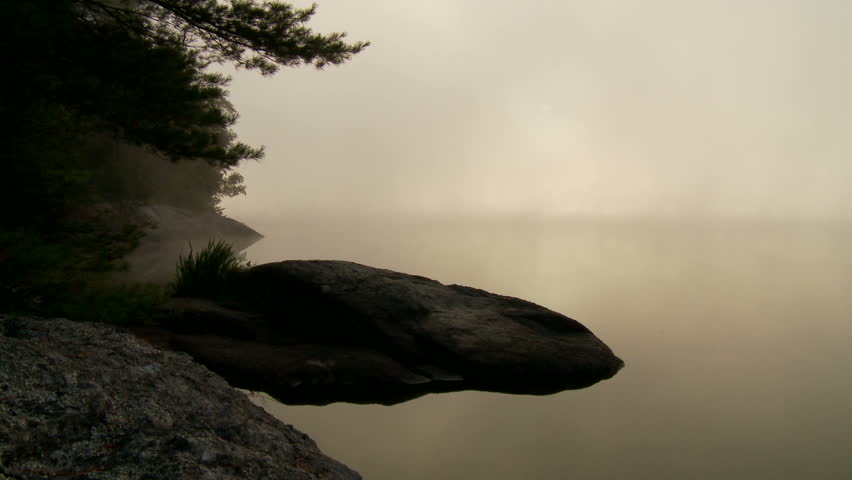 Dense fog over lake during dawn