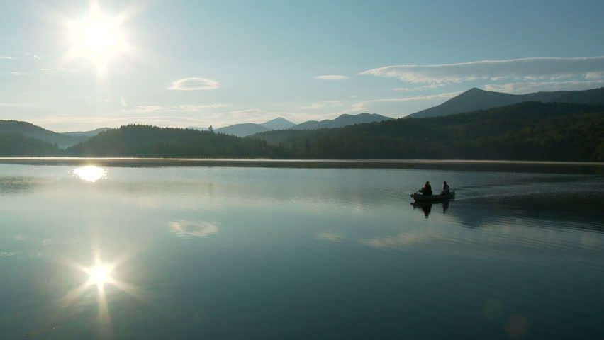 Canoe crosses beautiful clear lake