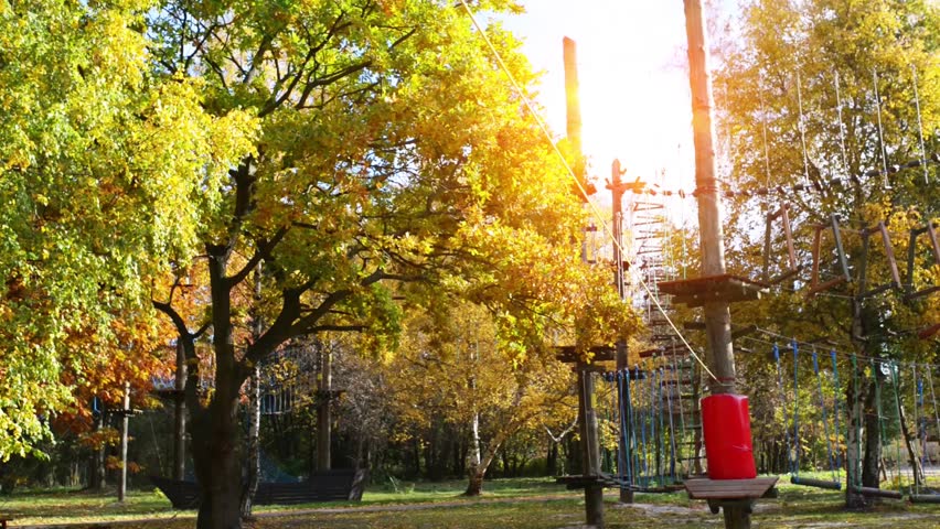 Small girl in adventure park. Adventure park is place which can contain wide variety of elements, such as rope climbing exercises, obstacle courses and zip-lines. They intended for recreation.